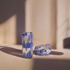 two glasses sitting on top of a table next to each other in front of a wall