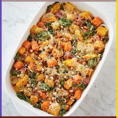 a casserole dish filled with vegetables and nuts on top of a marble counter