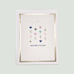 a card with hearts and stars hanging from it's sides, that says welcome little one