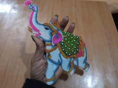 a hand holding an elephant made out of felt