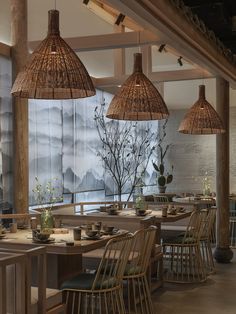 an indoor dining area with wooden tables and wicker lamps hanging from the rafters