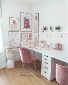 a white desk with pink chairs and pictures on the wall