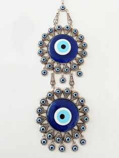 There are 2 Large Evil eye beads and 40 tiny evil eye beads on the silver hanging. Blue evil eye beads are 7 cm(2.7 in) Width of the zamak evil eye is 11.5 cm(4.5 in) Height of the metal evil eye hanging is 32 cm(12.5 in) You can place this Turkish ornament in your home or Office for protection. For more evil eye hangings, click the link below; https://www.etsy.com/shop/EyeDesignsbyGG?ref=search_shop_redirect&section_id=30211705 Bohemian Blue Evil Eye Bracelet For Festival, Bohemian Silver Evil Eye Bracelet, Bohemian Blue Evil Eye Jewelry, Handmade Blue Evil Eye Bracelet For Festival, Traditional Blue Evil Eye Jewelry, Handmade Blue Evil Eye Bracelet, Blue Evil Eye Bracelet For Festivals, Evil Eye Hanging, Evil Eye Decor