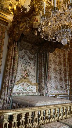 an ornate bed in a fancy bedroom with chandelier