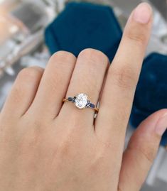 a woman's hand with a diamond and sapphire ring