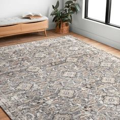 a large area rug with an ornate design on the floor in front of a window