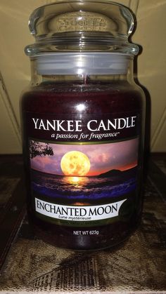 yankee candle with an image of the moon on it's lid sitting on a table