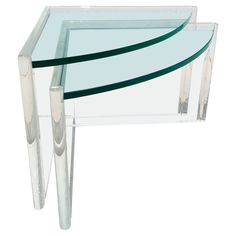 two glass tables with metal legs on each side, one has a curved edge and the other has a curved bottom