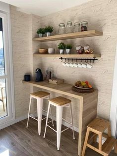 two wooden stools sitting in front of a counter with food on it and shelves above