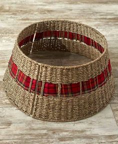 a basket that is on the floor with some red and white plaid fabric around it