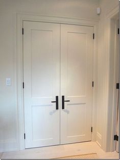 two white doors in a room with carpet on the floor