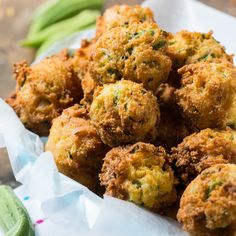 some fried food is in a basket on a table next to green beans and celery