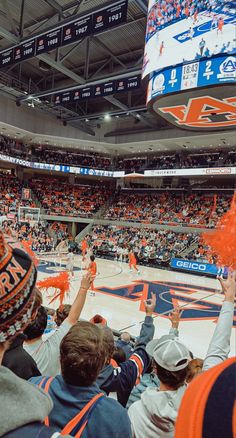 an orange and blue basketball game is being played on the court with fans in the bleachers