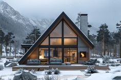 a house in the mountains with snow on the ground