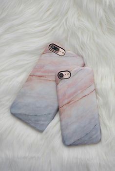 two cell phones laying next to each other on top of a white fur covered floor