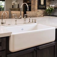 a large white kitchen sink sitting under a faucet