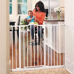 a woman and child are sitting at the kitchen counter in front of an open gate