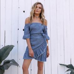 The Jordana Wrap Dress Features A Wrap Ruffle Front, Off The Shoulder Neckline, Ruffle Hem And Adjustable Tie Closure. Blue Bohemian Denim Dress For Spring, Denim Top With Frayed Hem For Day Out, Spring Bohemian Denim Blue Denim Dress, Washed Blue Chambray Denim Dress For Day Out, Fitted Dresses With Frayed Hem For Day Out, Blue Mini Dress With Frayed Hem, Chic Short Sleeve Denim Top For Summer, Chic Summer Short Sleeve Denim Top, Summer Denim Blue Short Sleeve Dress