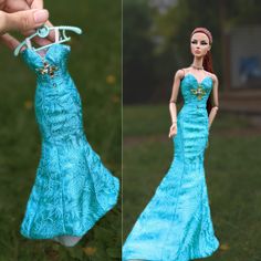 a barbie doll is wearing a blue dress and holding a hanger in her hand