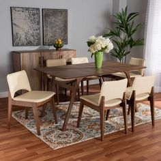 a dining room table with chairs and a rug