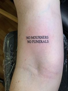 a person with a tattoo on their arm that says no mournners, no funerals