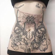 a woman's stomach with tattoos on it and flowers in the bottom part of her body