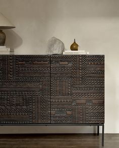 a large wooden cabinet sitting next to a lamp on top of a hard wood floor