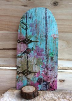 a wooden board with flowers painted on it and a piece of wood next to it