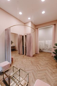 the inside of a wedding dress shop with pink curtains