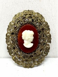 West Germany Filigree Two Tone White Cameo Brooch  This lovely piece can be worn on any occasion and is absolutely beautiful in the light, both inside and out, the perfect gift for anyone who loves vintage jewelry.  Colors and Shades may vary due to Lighting                            "Questions" Please read description carefully before buying to avoid confusion and cancellations. Please ask questions accordingly if needed. I do my best to answer emails promptly. - Measures Approx.  2" long - Each order comes shipped in a small drawstring pouch, all ready for     gifting. -If you are wanting to have this mailed as a gift to a special someone,  please write their address in the note section, otherwise it will be mailed to you. -If you would like to add a special typed note added to the orde Heirloom Brooches With Cabochon For Gifts, Antique Brooches With Vintage Charm As Gift, Antique Brooches With Vintage Charm For Gifts, Ornate Cameo Brooch For Anniversary, Ornate Cameo Brooches For Anniversary, Victorian Baroque Brooches As Gifts, Heirloom Cameo Brooch Gift, Heirloom Cameo Brooches As Gift, Heirloom Cameo Brooches For Gifts