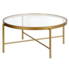 an oval glass coffee table with gold metal frame and clear glass top, viewed from the front