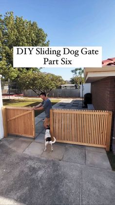 a man standing next to a wooden fence with a dog on it's back