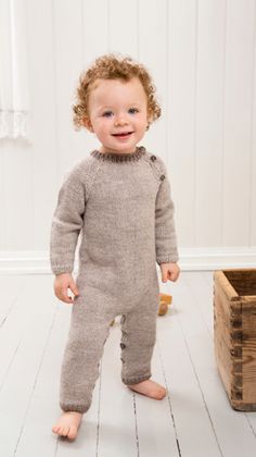 a young child standing next to a wooden box