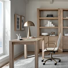 an office with a desk, chair and bookshelf next to a large window