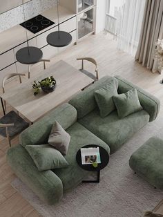 a living room filled with furniture next to a kitchen and dining room table on top of a hard wood floor