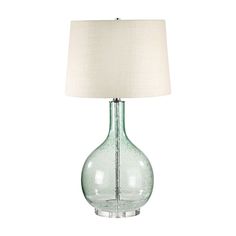 a green glass lamp with a white shade on it's base and a beige linen lampshade