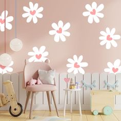 a child's room with pink and white flowers on the wall, wooden toy car