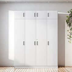 an empty room with two white cupboards and a potted plant