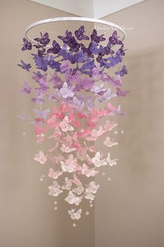 purple and pink butterflies are hanging from a chandelier in the corner of a room