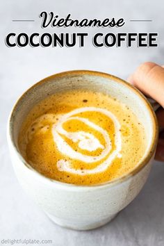 a hand holding a cup of coffee with the words vietnamese coconut coffee on top and bottom