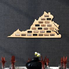 a large wooden cut out of the shape of a ship on top of a table with vases and flowers