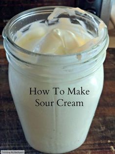 a jar filled with sour cream sitting on top of a wooden table