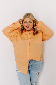 Channel all the good luck on your special day with this casual cute orange plus size top featuring lightweight material, a button up front with a collared neckline, long loose sleeves with roll tab cuffs, a single accent chest pocket, and a relaxed silhouette that falls into a rounded hemline! Measurements 1XL : Bust 58", Hip 54", Length 35", Sleeve Length 15", Waist 53". 2XL : Bust 60", Hip 55", Length 36", Sleeve Length 16", Waist 54". 3XL : Bust 62", Hip 56", Length 35.5", Sleeve Length 15.5", Waist 55". Peach Long Sleeve Blouse For Fall, Long Sleeve Peach Blouse For Fall, Orange Long Sleeve Blouse With Relaxed Fit, Oversized Orange Shirt With Long Sleeves, Trendy Orange Long Sleeve Shirt, Orange Long Sleeve Top With Buttons, Orange Relaxed Fit Long Sleeve Blouse, Orange Button-up Blouse For Fall, Oversized Long Sleeve Orange Blouse