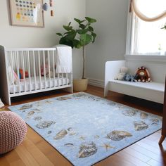 a baby's room with a blue rug and white crib