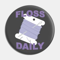 a button that says floss daily with a spool of yarn in the middle