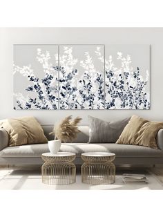 a living room with two couches and paintings on the wall above them in blue and white