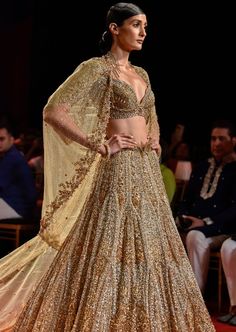 Molten gold heavily embroidered lehenga paired with crystal encrusted blouse and cape veil across shoulder glamourized with a feather tulle trail. Lehenga Cape, Cape Veil, Molten Gold, Cape Set, Rahul Khanna, Payal Singhal, Embroidered Lehenga, Potli Bags, Nehru Jackets