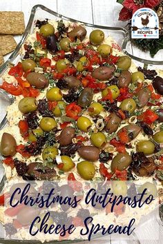 a christmas appetizer cheese spread with olives, tomatoes and other toppings