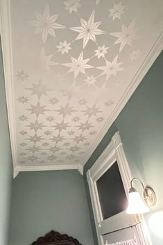 a woman standing in a bathroom under a white ceiling with stars painted on the ceiling