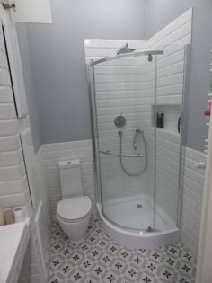 a white toilet sitting next to a walk in shower